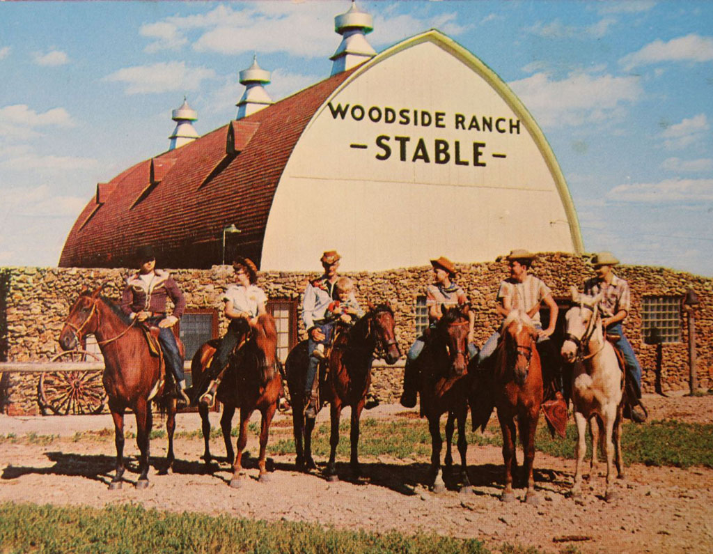 People On Horses In Front Of The Stable